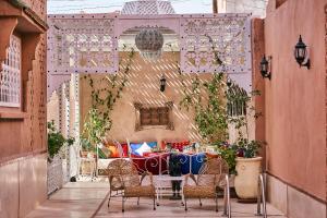 a patio with a table and chairs on a patio at Riad Ouarzazate in Ouarzazate