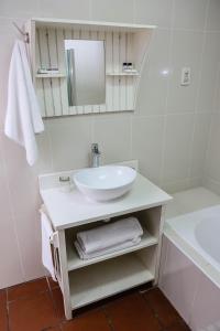 W białej łazience znajduje się umywalka i lustro. w obiekcie Newcastle Country Lodge w mieście Newcastle