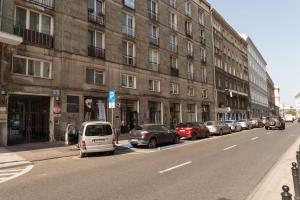 uma rua com carros estacionados ao lado de um edifício em City Center Boutique Apartment em Varsóvia