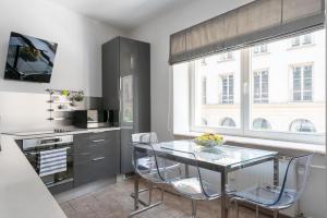 a kitchen with a glass table and chairs at City Center Boutique Apartment in Warsaw