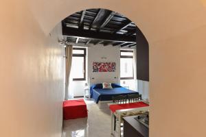 ein Zimmer mit einem blauen Bett und einem Tisch in der Unterkunft Urbana Colosseo Boutique Apartment in Rom