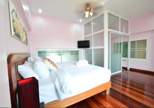 a bedroom with a large white bed and a television at Ayi Home in Bangkok +44 photos