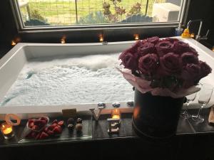 a vase of roses sitting in a bath tub at Spa Suites at RAVEN in Hepburn Springs