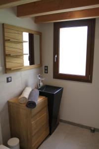 La salle de bains est pourvue d'un lavabo noir et d'une fenêtre. dans l'établissement Le chalet des Pierres, à Viuz-en-Sallaz