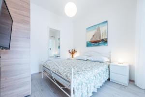 a white bedroom with a bed and a painting on the wall at Luxury Apartments in Dubrovnik