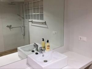 biała łazienka z umywalką i lustrem w obiekcie Beach apartment garden and wifi w mieście Tarifa