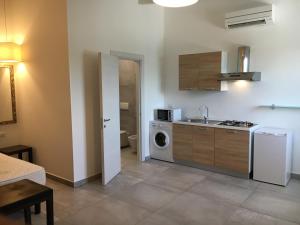 une cuisine avec un évier et une machine à laver dans l'établissement Residenze La Villa, à Foggia