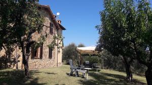 a garden with a picnic table and an umbrella at Casa Vacanze Porta Vecchia in Montalcino