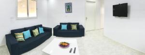 uma sala de estar com dois sofás azuis e uma mesa em Dwiret Hayet Kélibia em Kelibia