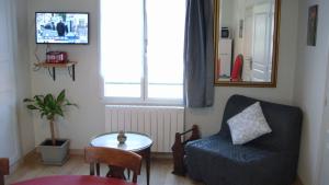 a living room with a couch and a table and a window at gite montreuil le henri 2 pers in Montreuil-le-Henri