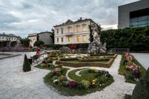 a building with a garden with flowers in front of it at SISHAUS - Private Room Rental in Salzburg
