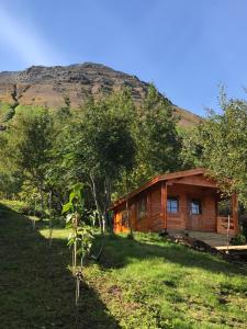 a log cabin with a mountain in the background at The Herring House in Siglufjörður