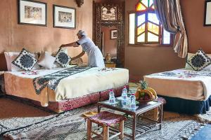a man standing on two beds in a room at Riad Ouarzazate in Ouarzazate