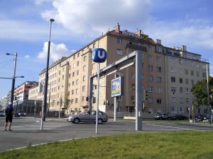 a man standing in a parking lot in front of a building at Apartment Paradies - U1 Station altes Landgut in Vienna