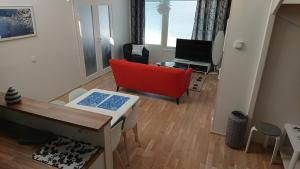 ロヴァニエミにあるReindeer City Apartmentのリビングルーム(赤い椅子、テレビ付)