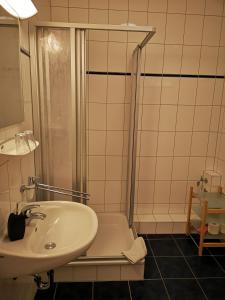 a white bathroom with a sink and a shower at Golfcentrum Schloss Karnitz Rügen in Garz-Rügen +42 photos