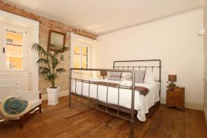 um quarto com uma cama e uma cadeira em 1861 Liston Boutique flat em Corfu Town