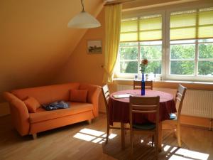 a living room with a table and a couch at Golfcentrum Schloss Karnitz Rügen in Garz