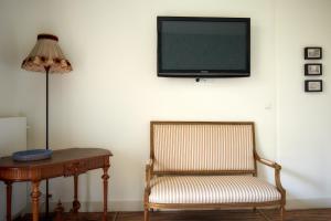 a chair and a table with a television on a wall at B&B Muntzicht in Utrecht