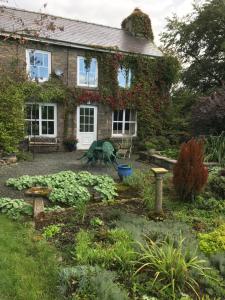 un giardino di fronte a una casa in mattoni di Pen y Crug Cottage a Llanafan-fawr