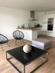 a living room with a table and two chairs and a kitchen at le vergoyer in Calais