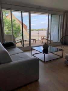 a living room with a couch and a glass table at le vergoyer in Calais