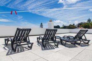 dos sillas negras sentadas en la azotea en Arquinha Apartment, en Ponta Delgada