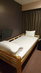 a bedroom with a bed with white sheets at Tokyo Ariake Bay Hotel in Tokyo