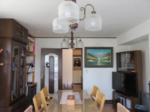 a dining room with a glass table and chairs at Hostel Kamakura in Kamakura