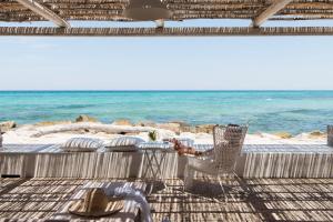 a person sitting in a chair on the beach at La Peschiera in Monopoli