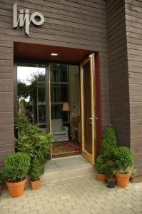 an entrance to a building with plants in pots at Lijo in Gargždai