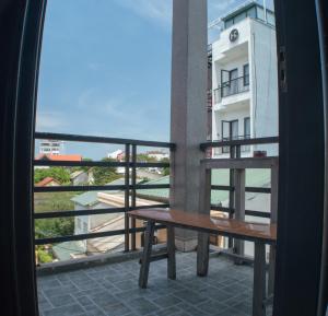a balcony with a table and a view of a building at Hue Happy Homestay in Hue