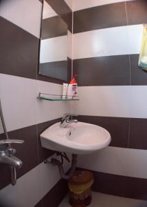 a white sink in a bathroom with black and white stripes at Hue Happy Homestay in Hue