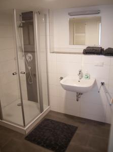W łazience znajduje się umywalka i prysznic. w obiekcie La Flamme Wertheim garni w mieście Wertheim