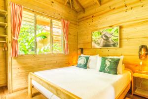 um quarto com uma cama num quarto de madeira em Hotel El Mono Feliz em Ojochal