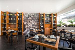 a dining room with tables and chairs and a painting on the wall at Residencial Mar e Sol in Costa da Caparica