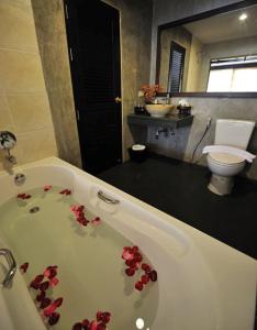 a bathroom with a bath tub with red flowers on it at Siralanna Hotel in Patong Beach