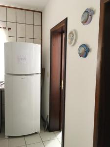 a kitchen with a white refrigerator and a door at Excelente Casa em Bombas in Bombinhas