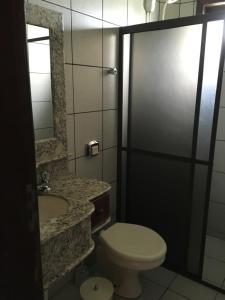 a bathroom with a toilet and a sink at Excelente Casa em Bombas in Bombinhas +44 photos