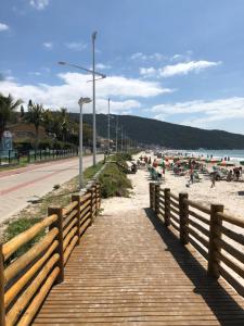 a wooden boardwalk on a beach with people on it at Excelente Casa em Bombas in Bombinhas
