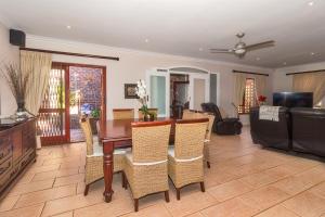 a living room with a wooden table and chairs at 84 De Mist Guesthouse in Port Elizabeth