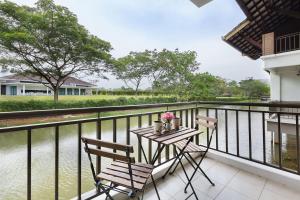 een balkon met een tafel en stoelen en water bij Modern Bali Resort by HostaHome, 10mins to Legoland in Nusajaya