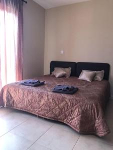 Apartment in Polis Neo Chorio في بوليس خريسوخوس: سرير عليه اثنين من الملابس