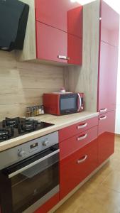 a red kitchen with a stove and a microwave at Apartment Goran & Nela in Umag