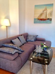 sala de estar con sofá púrpura y velero en Apartments Villa Bare en Kastav