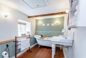 ein Badezimmer mit Badewanne und Waschbecken in der Unterkunft Three Little Pigs Luxury Cottage in Milton Abbas + 67 Fotos