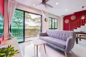a living room with a purple couch and a sliding glass door at Modern Bali Resort by HostaHome, 10mins to Legoland in Nusajaya
