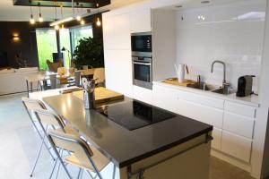 a kitchen with a black counter top and white cabinets at Archibien in Bois-de-Villers