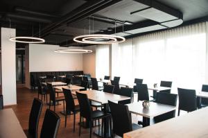 una sala da pranzo con tavoli, sedie e finestre di Jet Hotel Zurich Airport a Rümlang