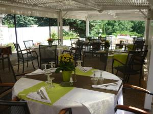 a group of tables and chairs in a restaurant at Logis Hotel Le Relais du Serre in Dieulefit